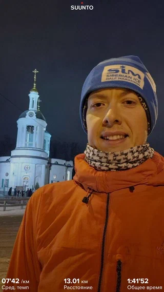 Портрет на зимней пробежке на фоне освещённого здания