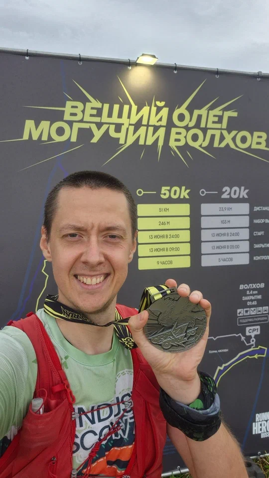 Портрет с медалью на фоне баннера забега на Волхове